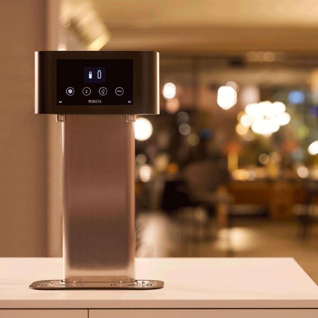 BRITA Fill T-Tap dispenser hero shot showing touch display and four water type controls in a UK hotel