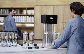 BRITA Fill T-Tap dispenser on a cafe counter with reusable glass bottles ready for UK hospitality service
